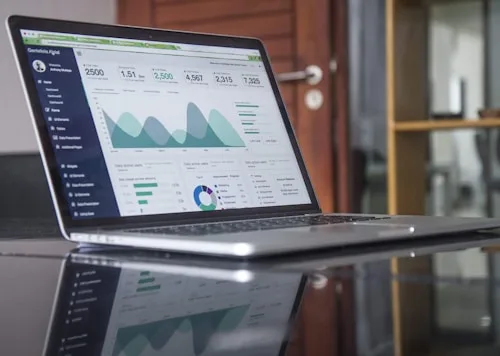 Data Visualization | CAQA Creative A laptop screen shows a data analytics dashboard with charts and metrics relevant to creative arts.