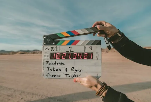Desert Film Production | CAQA Creative A clapperboard sits on a desert roadside during film production, showcasing creative arts services.