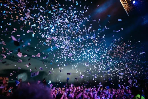Indoor Concert | CAQA Creative A large crowd enjoys a concert with confetti falling, showcasing creative arts events.