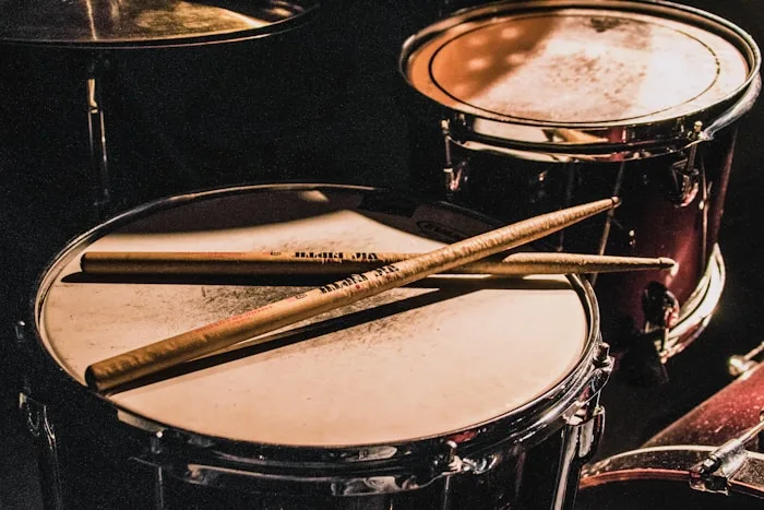 A Vic Firth drum kit with wooden sticks resting on the snare, showcasing music production equipment.